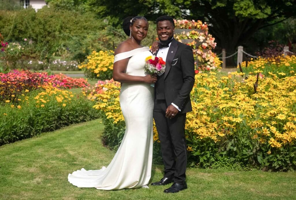 African couple posing for traditional, formal wedding portrait, happy.