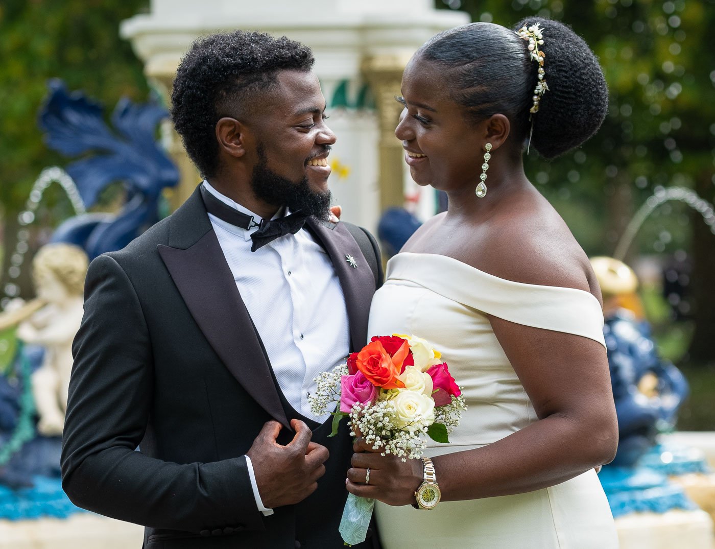 Happy African couple smiling and looking towards each other in garden.